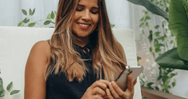 woman on her phone using tiktok and smiling