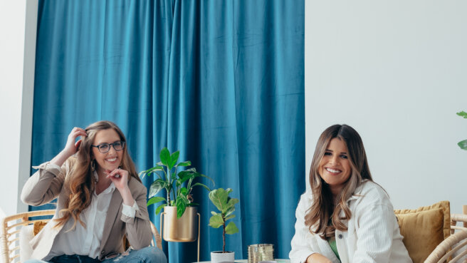 two professional women in an office meeting area